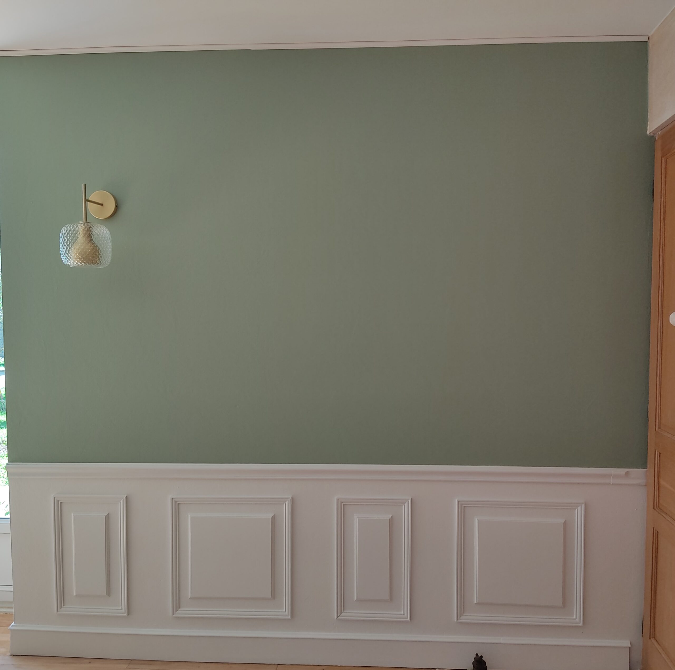 Moulure posée sur un mur vert d'eau